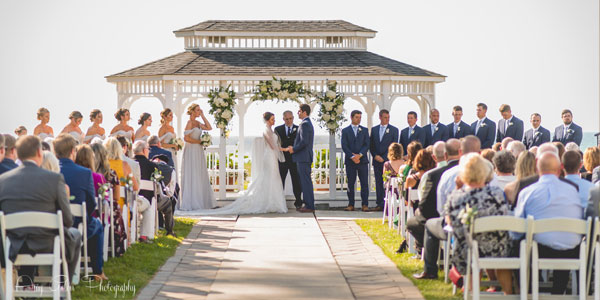 Wedding ceremony taking place outdoors at The Lodge at Geneva-on-the-lake